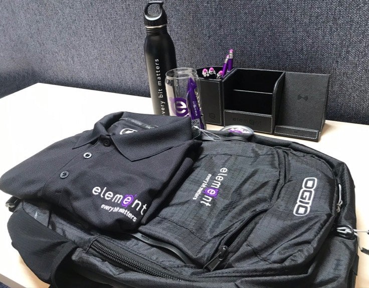 A black backpack, black collared shirt and water bottle all showing the element logo.