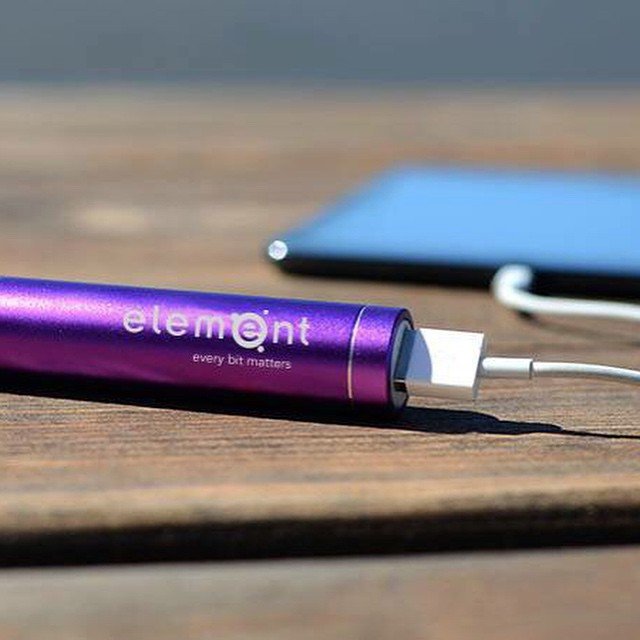 A purple, portable charger with the element logo on it.