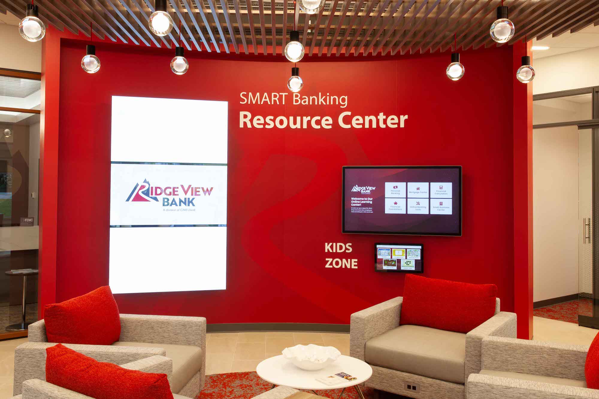 a red lobby with tv's and screens on the walls