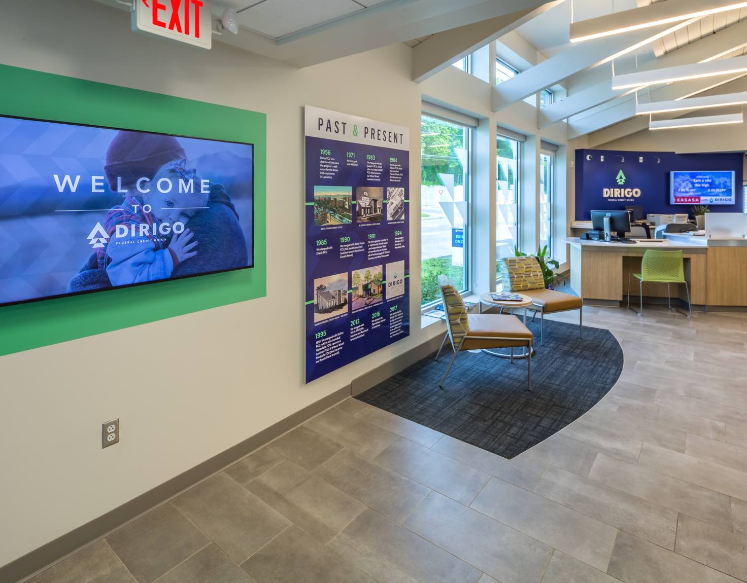 A bank lobby with a screen on the wall that says Welcome