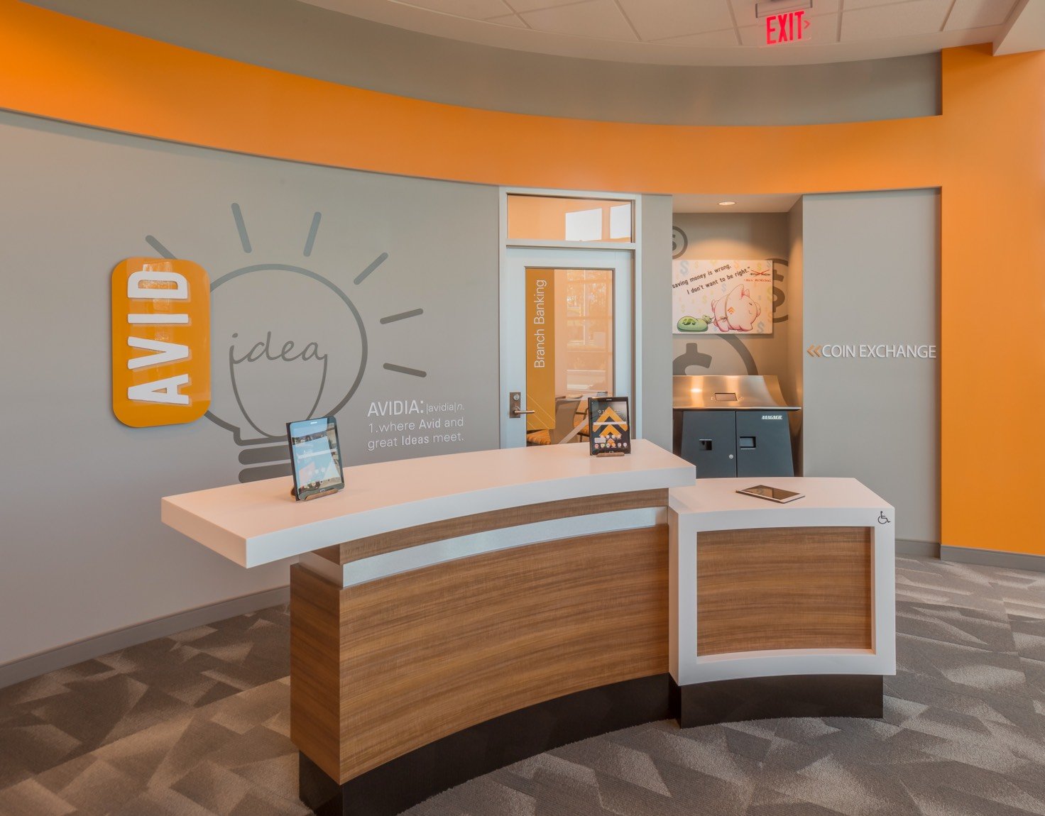 An orange and grey bank counter with an idea lightbulb detailed on the wall.