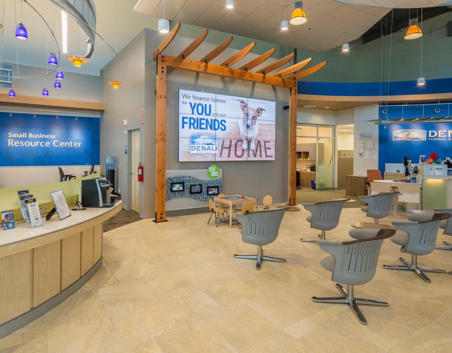 A waiting room in a bank with a wall of screens displaying a dog.