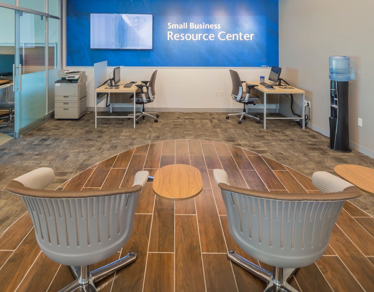 A business resource center lobby with desks and waiting chairs.