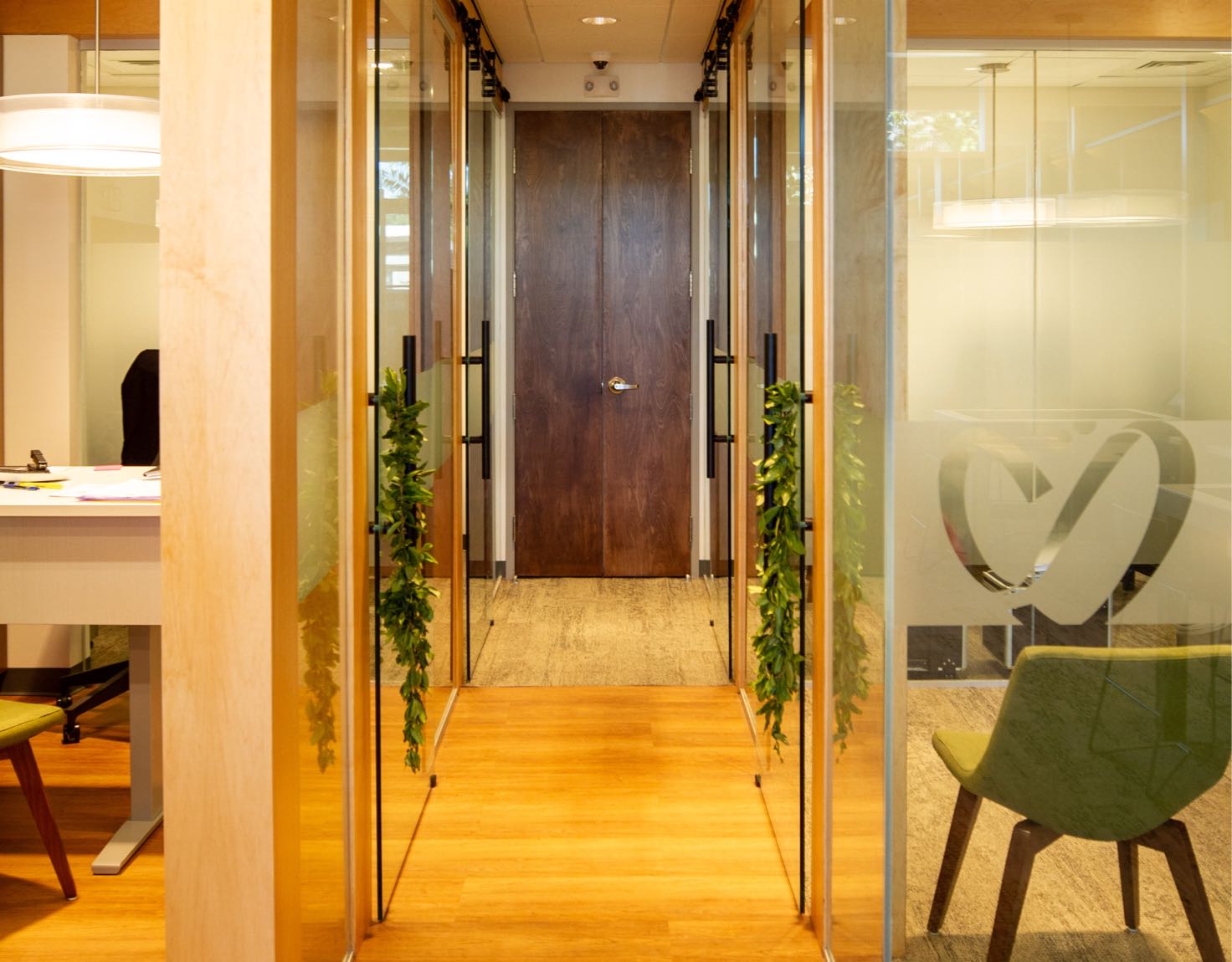 A hallway with glass offices on either side.