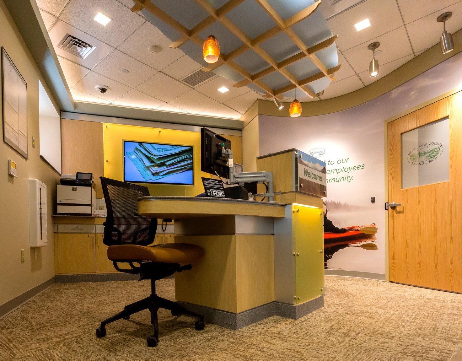 A bank office featuring a desk and chair, creating a welcoming and professional environment for customers at Merrimack County Savings Bank.