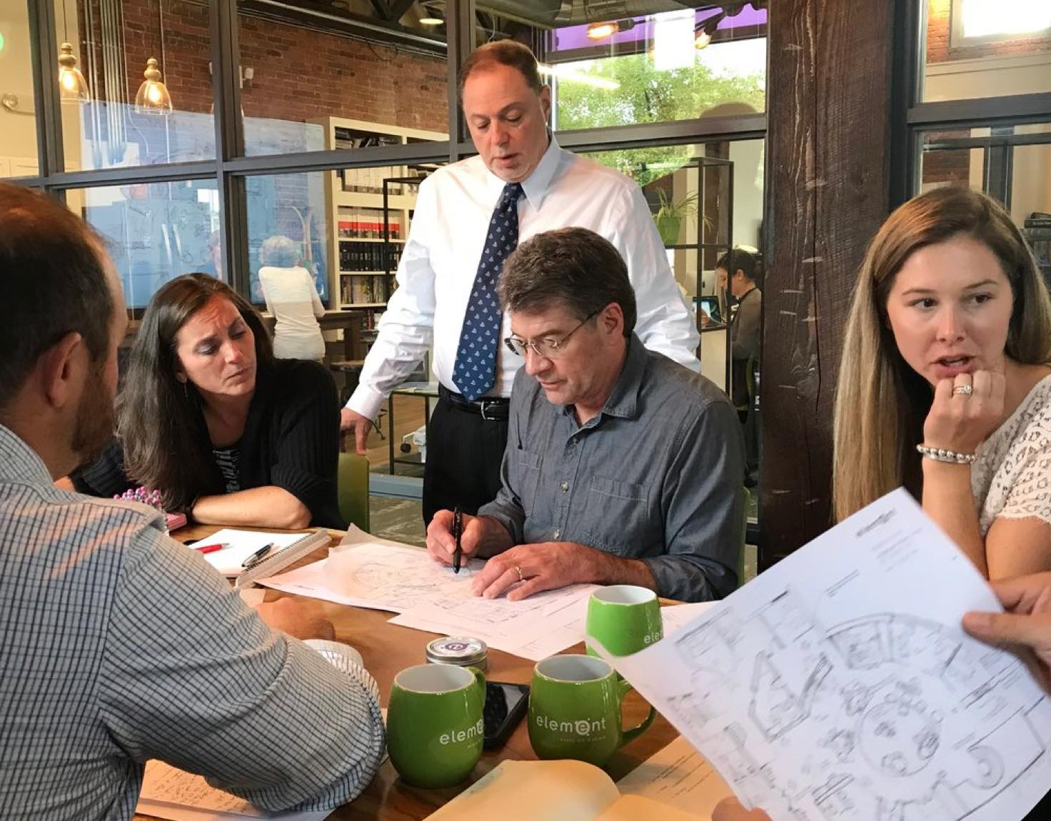 A group of coworkers sitting at a table looking at papers.