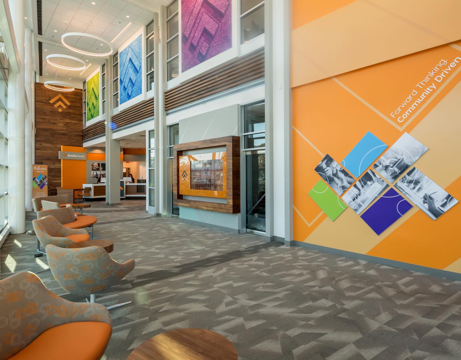 A large waiting area with orange upholstered chairs and orange walls.