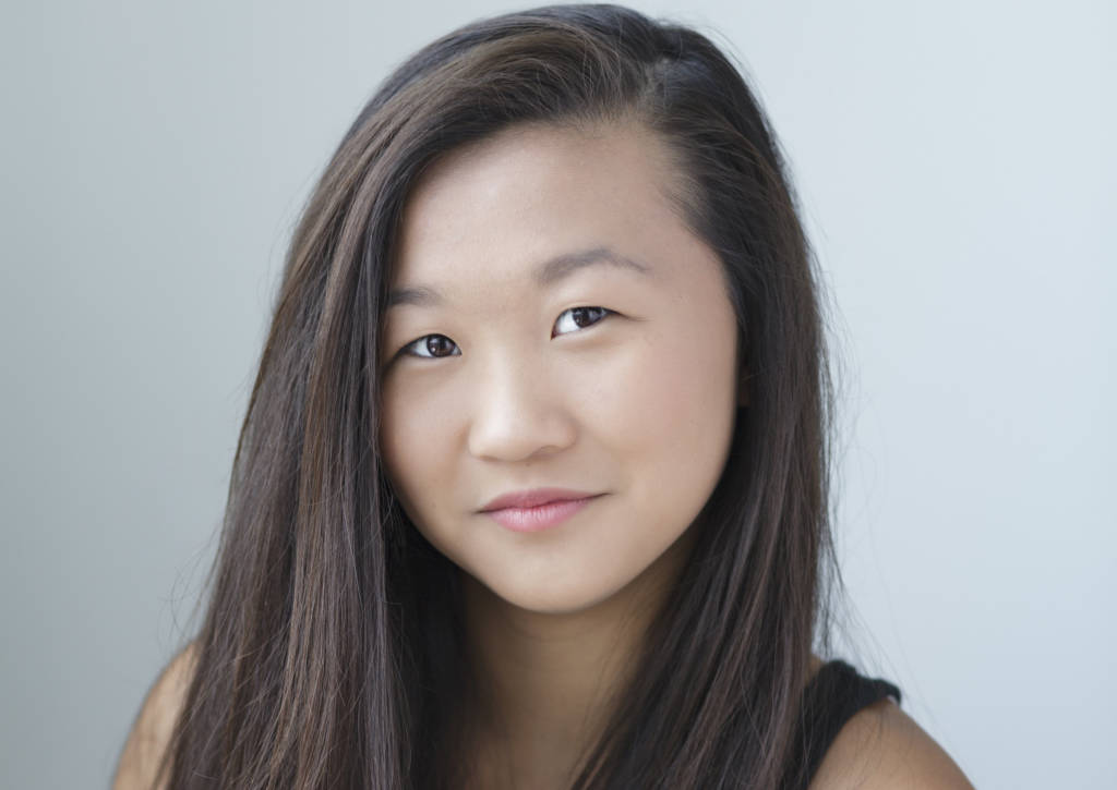 A young woman in a black tank top.