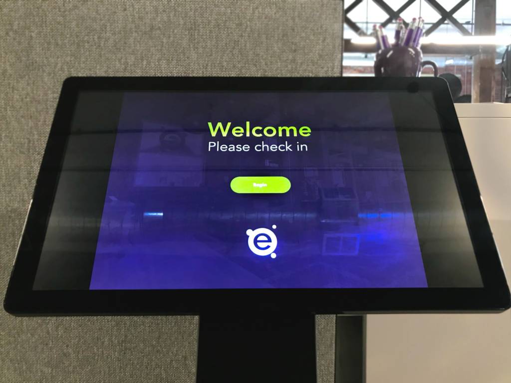A Touchscreen, podium, asking you to check in.