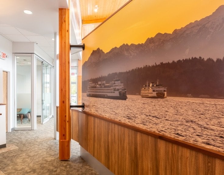 A hallway with a mural of two ships on the water.