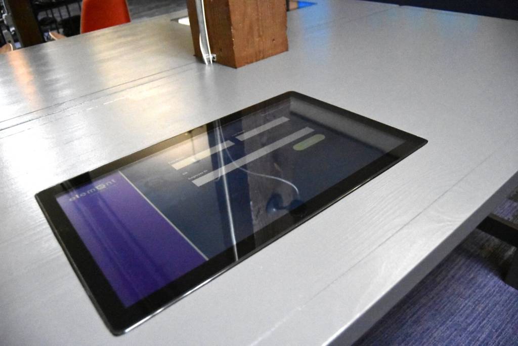 A table with a small touchscreen built into the top.