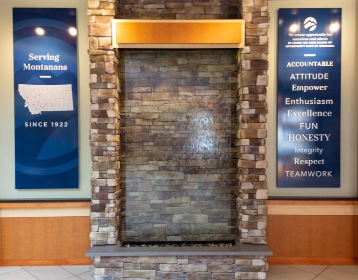 A tall, stone fireplace with a blue sign on either side of it.