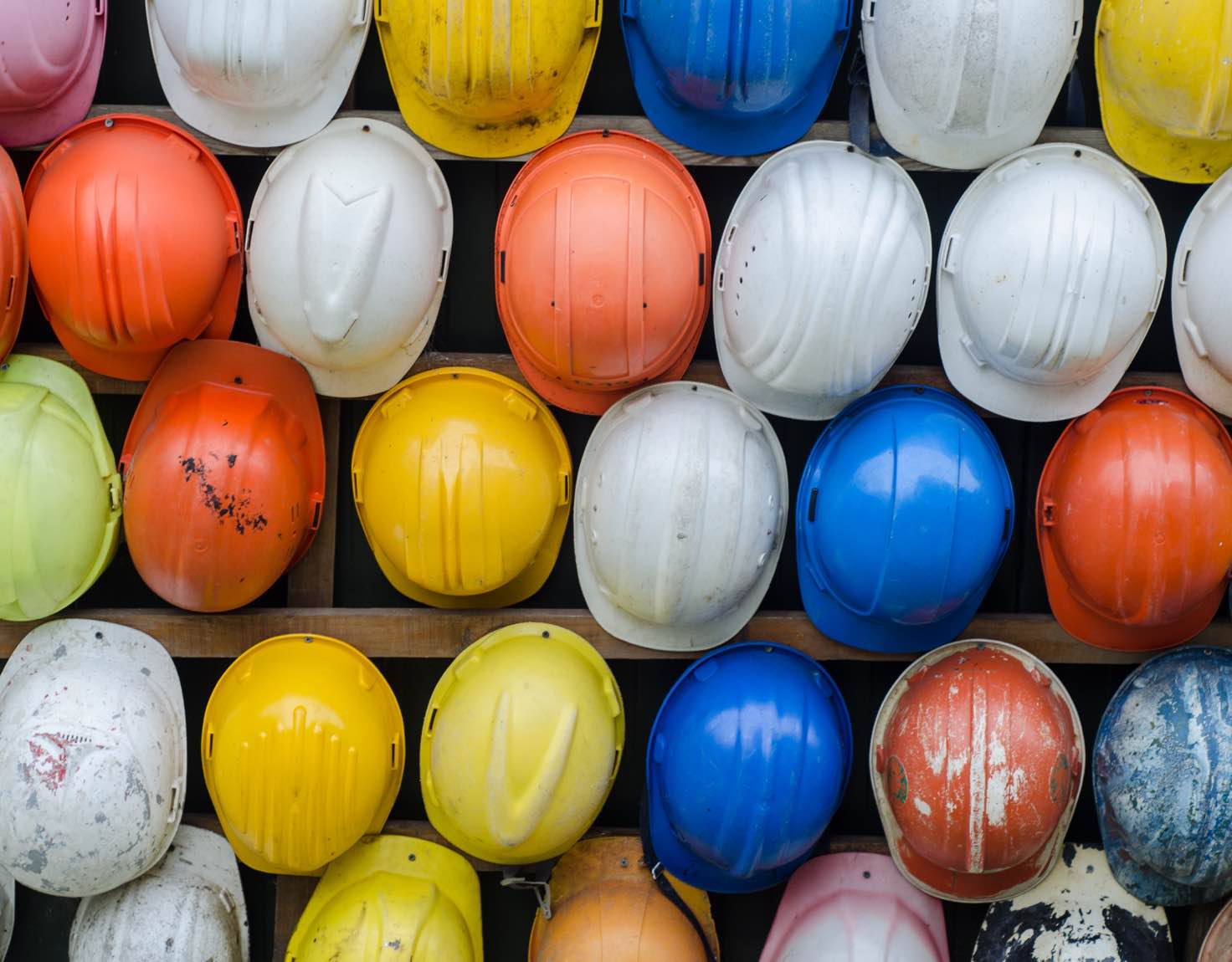 colorful hard hats hung on wall