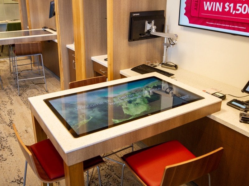 Chairs surrounding a table with a touchscreen top.