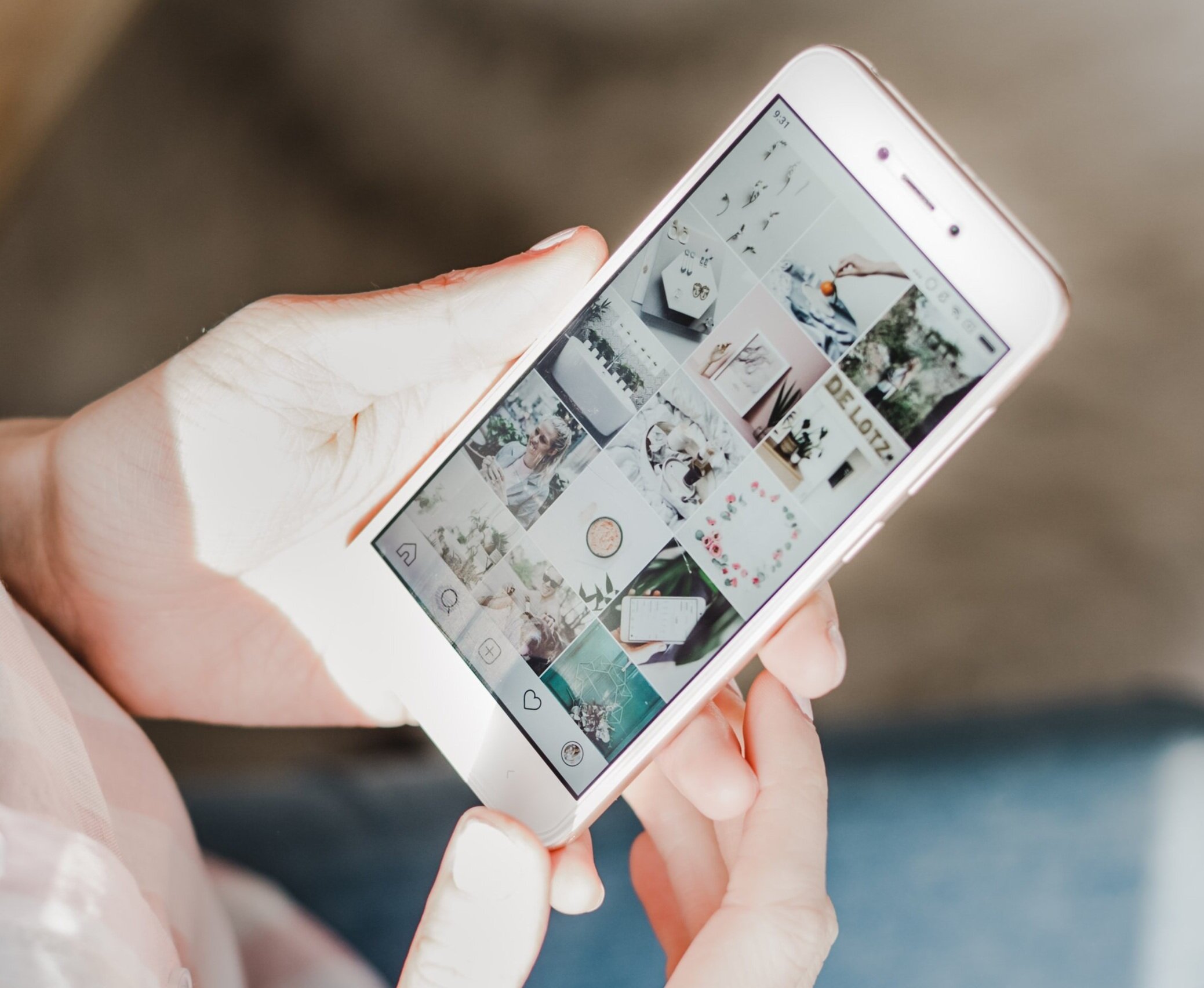 A woman holding a phone, displaying an instagram page.