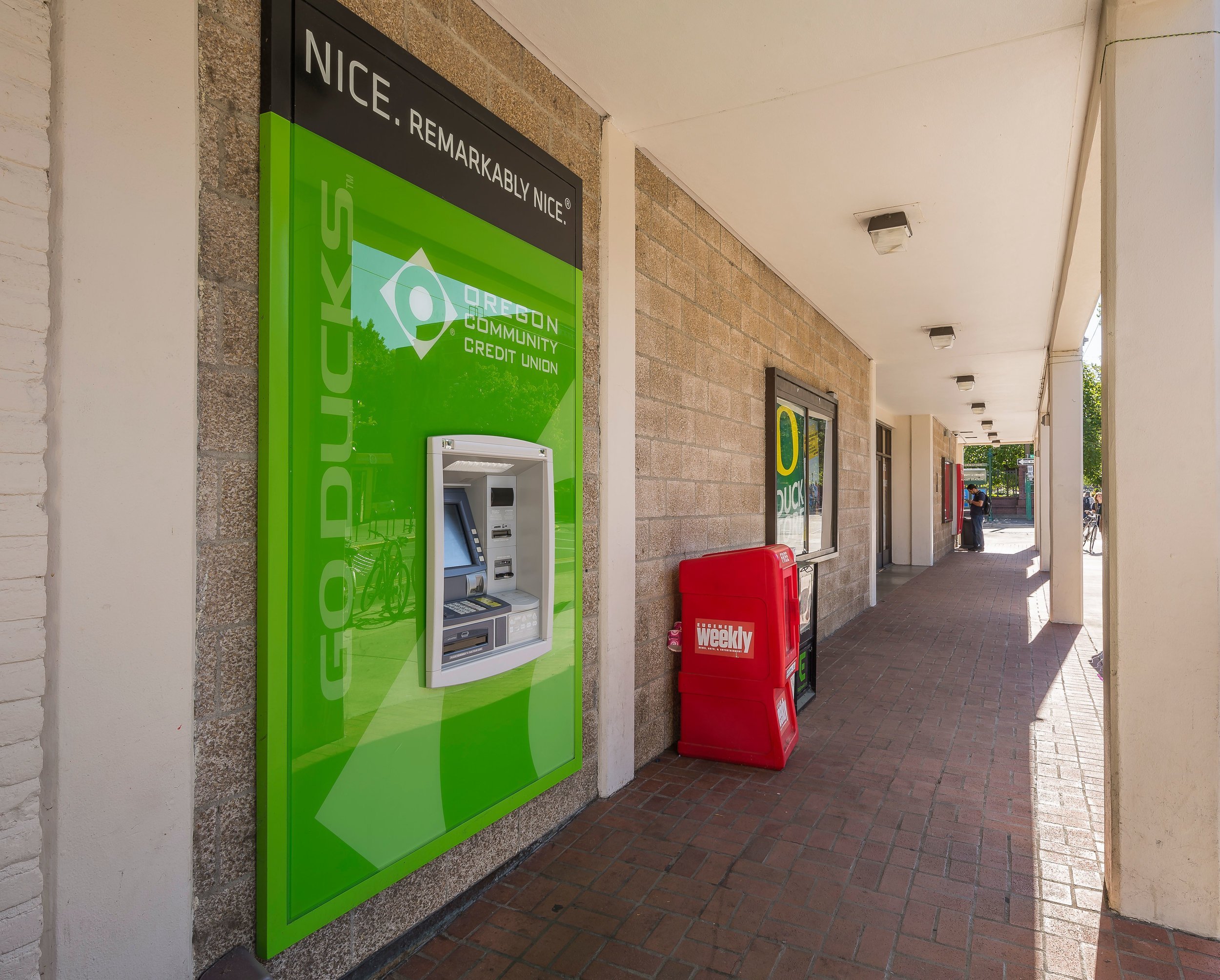 A green ATM outside of a building.