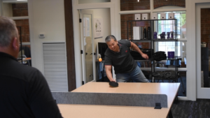 Two coworkers playing ping pong in the office.