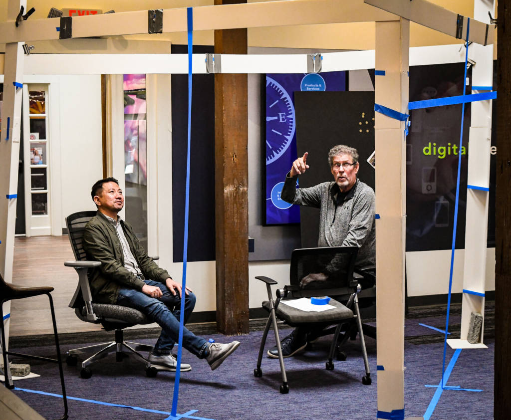 Two men meeting in a room under construction.