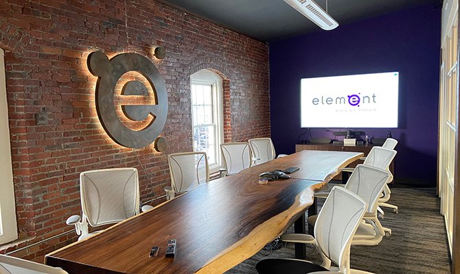 The Element Groups conference room featuring a large screen at the front and several chairs arranged for attendees.