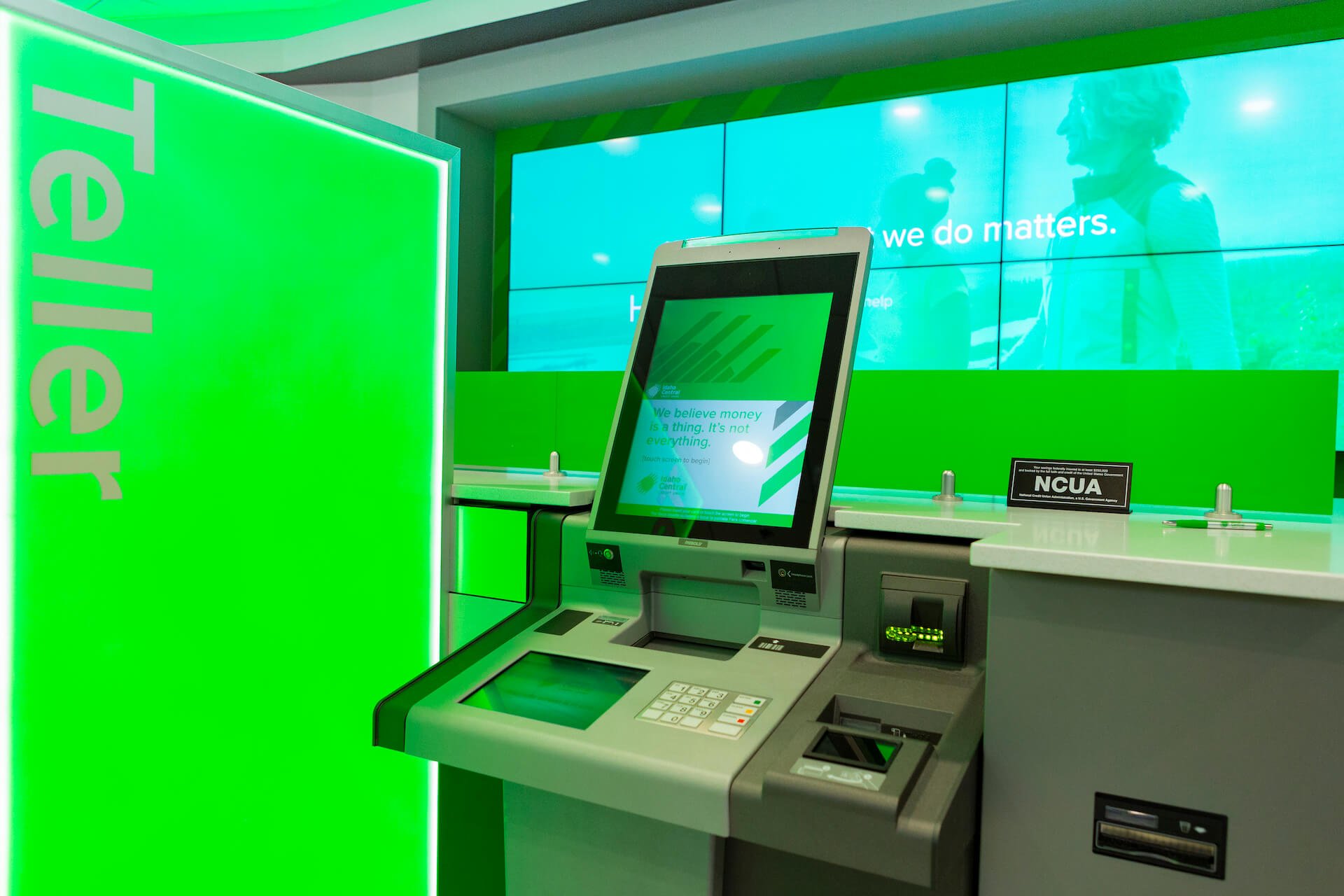 A green glowing screen labeled "Teller" next to an atm machine.