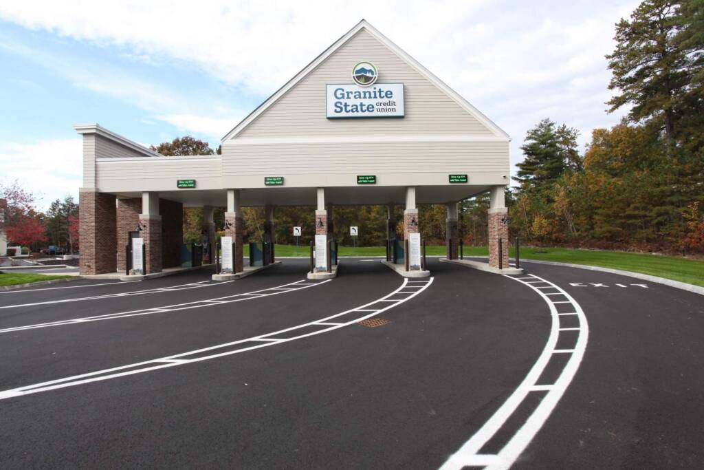 Exterior view of a Granite State Credit Union drive-through with multiple lanes and self-service interactive teller machines and clear signage.