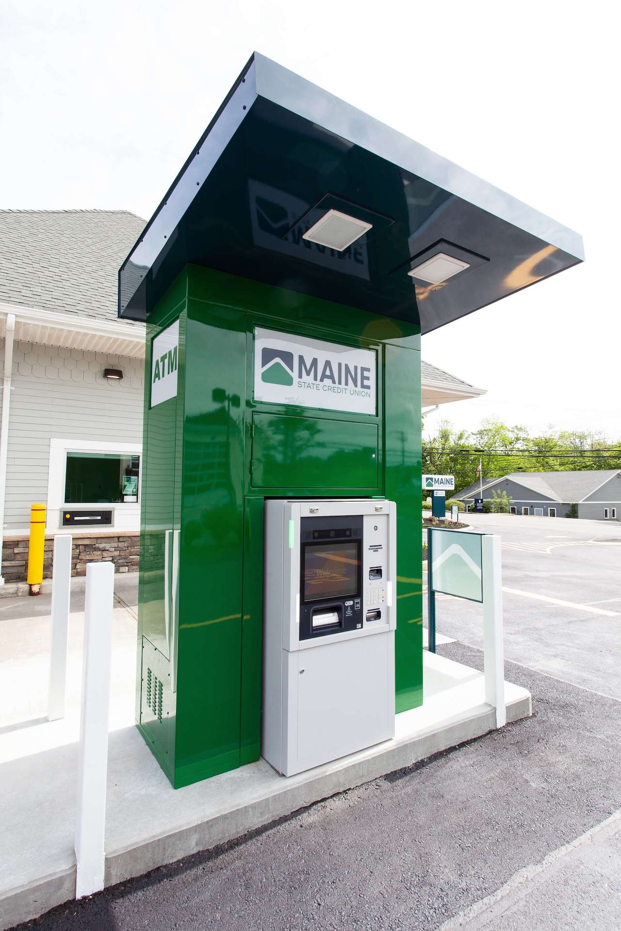 A drive-up ATM kiosk for Maine State Credit Union, painted green with the logo on top, under a protective overhang.