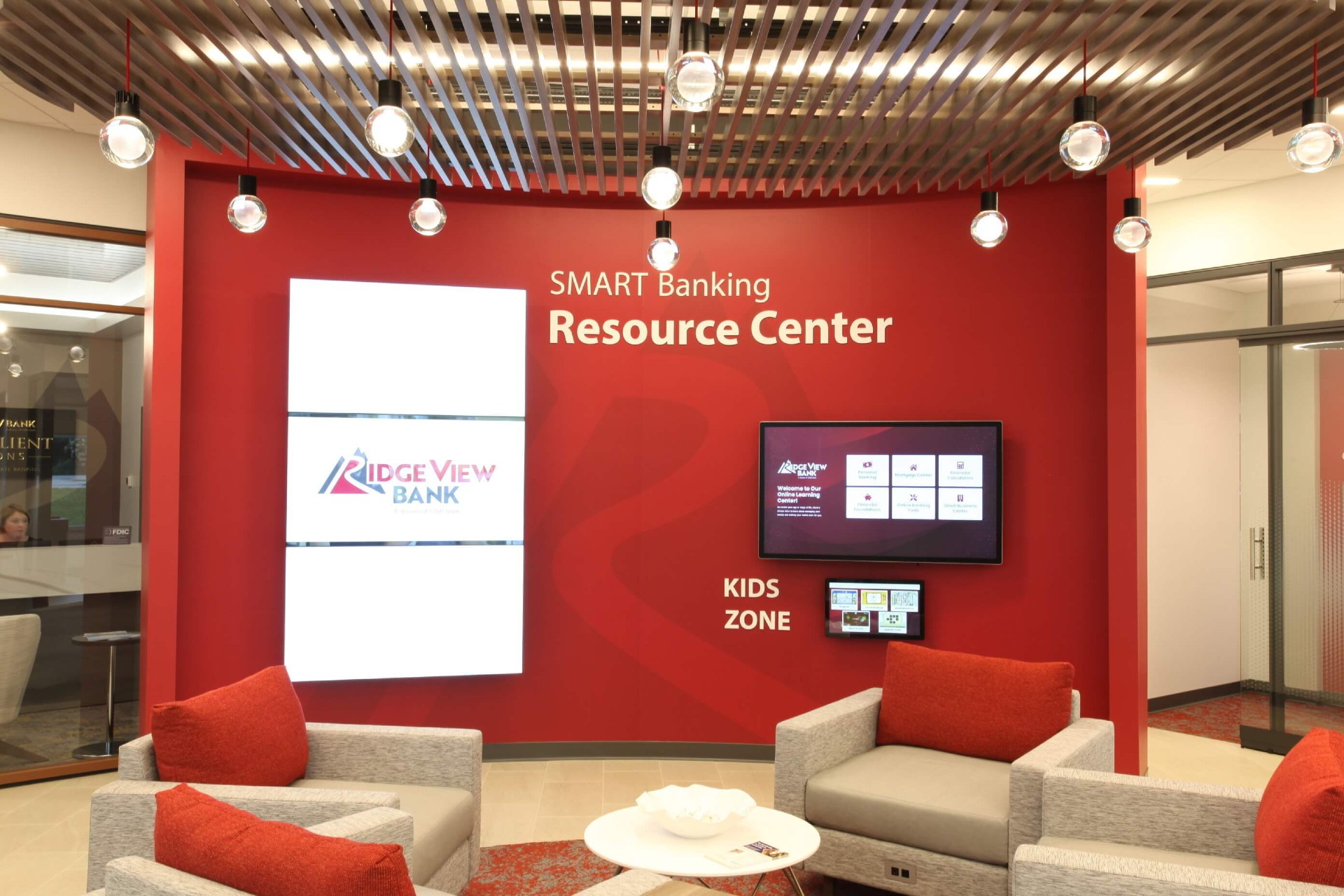 A modern interactive banking resource center with digital screens and a comfortable waiting area at Ridge View Bank.