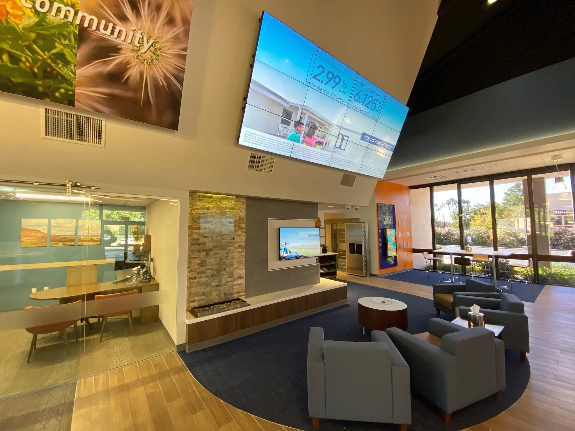 A spacious bank lobby featuring a large screen and comfortable chairs for guests to relax and enjoy at Desert Financial Credit Union.