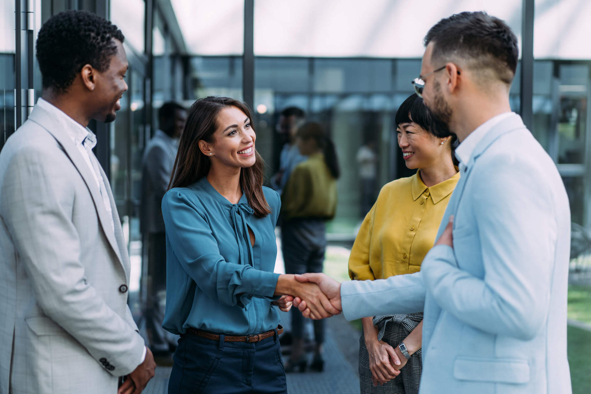 man shaking hands with a woman in the lobby of a workspace