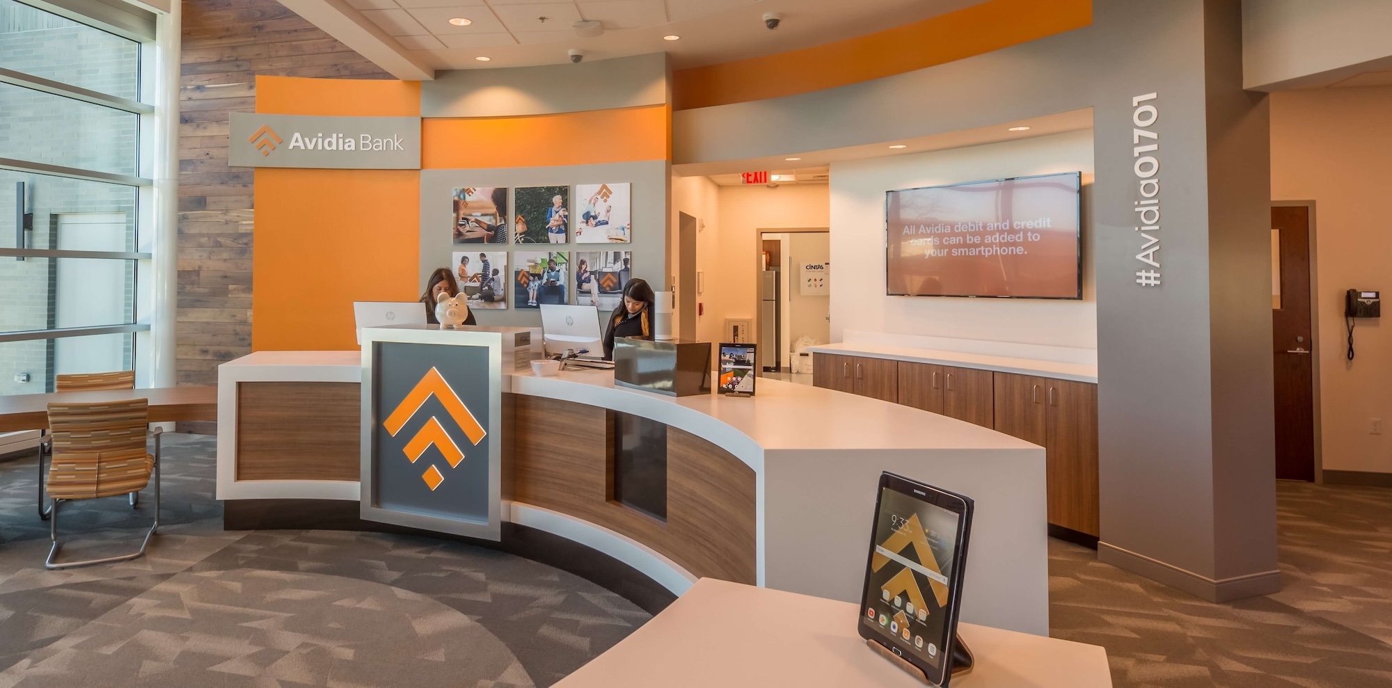 digital signage behind bank teller line